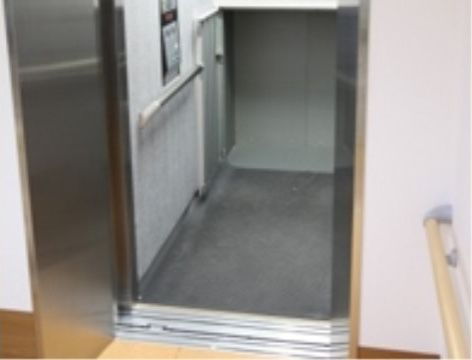 庫内にも手すりがつけられている、扉が開いたままのエレベーター