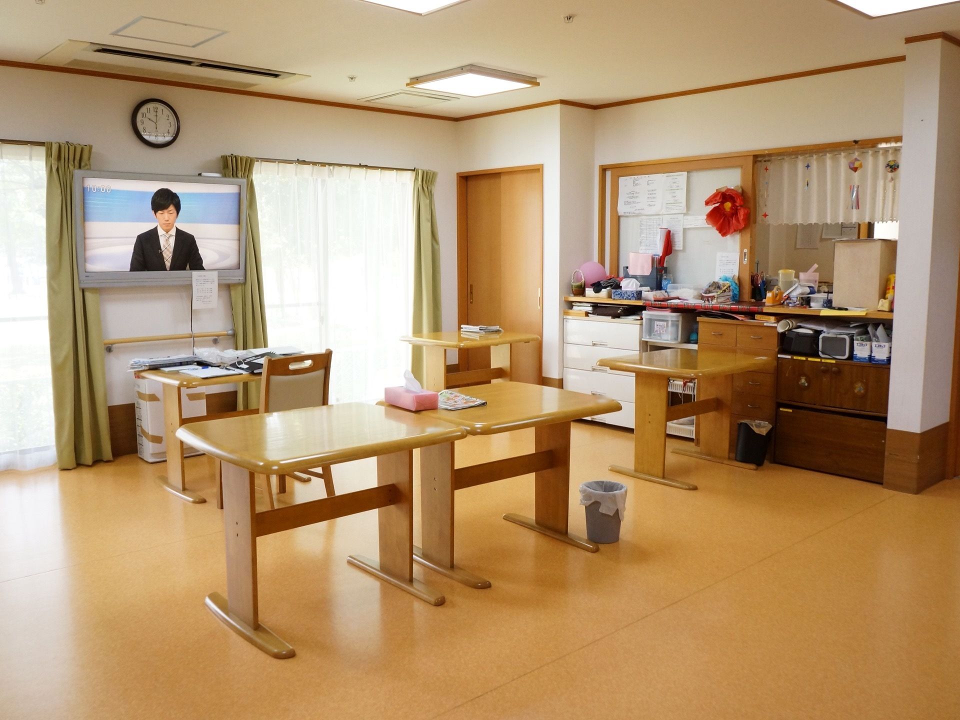 車椅子のまま利用できるテーブルを備えた共有スペースである。腰高窓からは自然光が十分に差し込み、大変明るい場所である。