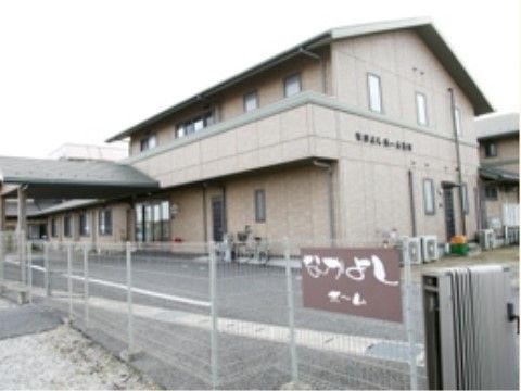 鉄製のフェンスで周囲を囲まれている、三角屋根の２階建ての建物