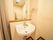 居室のトイレ内にある洗面台。壁には鏡があり、一部は物を置ける棚になっている。タオルハンガーも付けられている。