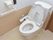 トイレはウォシュレット式で右側には手すりがついている。その上にトイレットペーパーと呼び出しベルも備え付けられている。