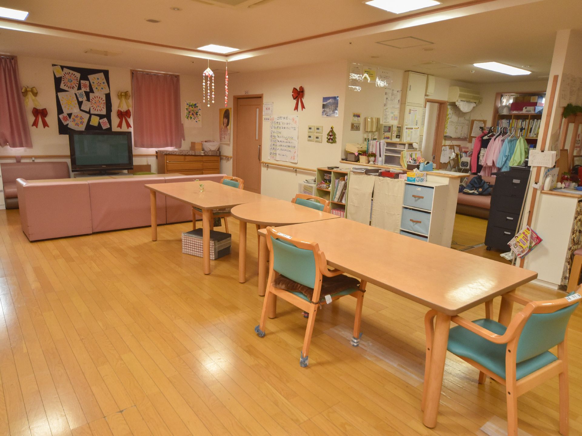 ダイニングには長方形のダイニングテーブル2台の間に半月型のテーブルが挟まれた配置で、ひじ掛けつきの椅子が4客備わっている。