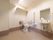 広々としたトイレスペースには、便座の前方に洗面台を設置している。立ち座りの動作がより安全に行えるように、Ｌ字型の手すりを採用している。