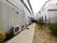 敷地内施設建物の周りはフェンスで囲まれている。フェンス近くには木が植えられている。建物横には室外機が並べられている。
