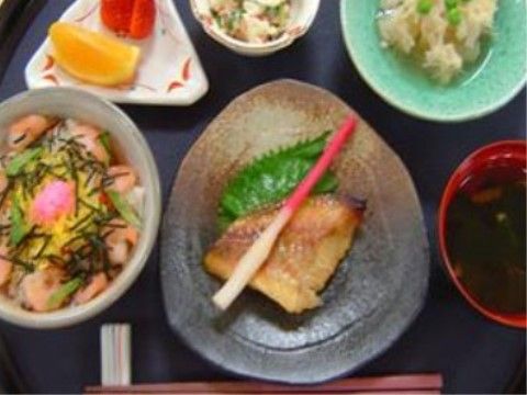 鮭のちらし寿司の横に焼き魚が添えられている食事の一例