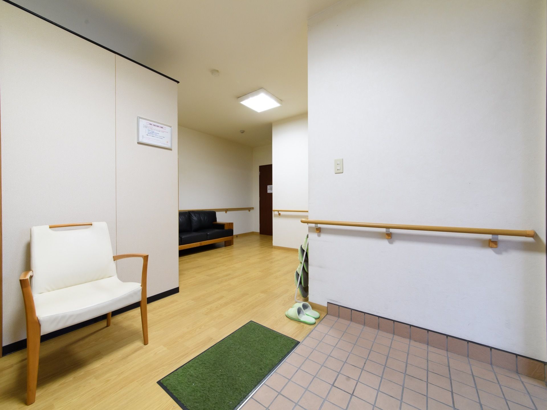 玄関はバリアフリーになっている。玄関を上がってすぐの場所にはひじ掛けと背もたれ付きの椅子が置かれている。
