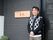 施設の入口に男性スタッフが立っている。優しさを感じさせる服装と、あたたかみのある笑顔のスタッフがお見守りをしている。