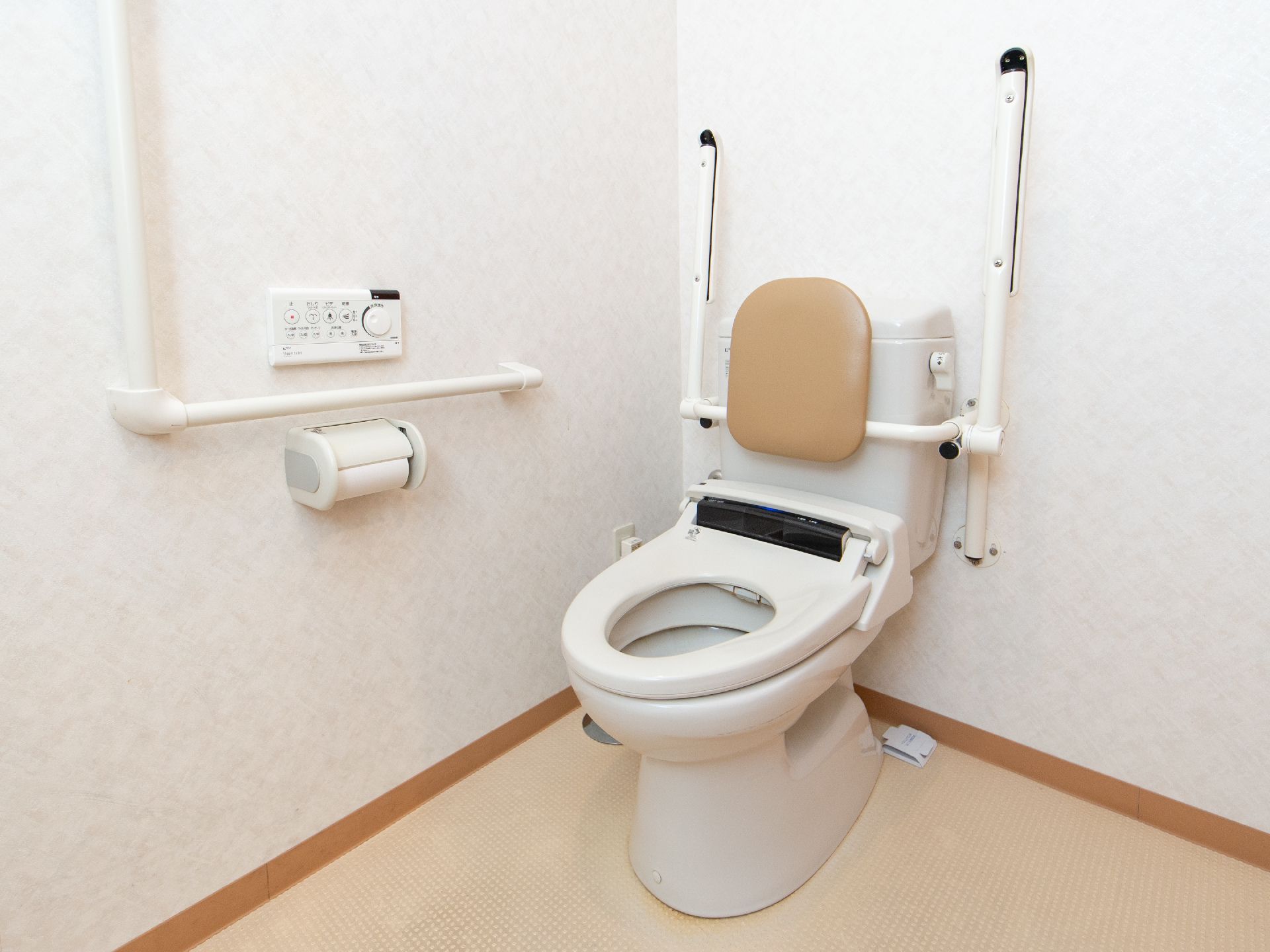 温水洗浄便座を採用したトイレを設置している。操作ボタンが壁にあるので操作がしやすく、可動式の背もたれが取りつけられている。