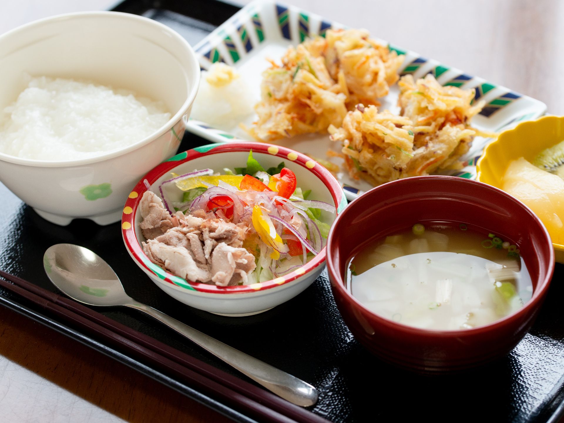 柔らかく炊かれたごはんと、かき揚げとサラダが並んだ食事