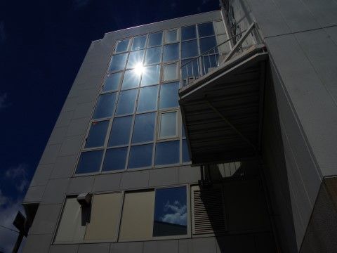 外部のガラス窓に太陽が反射していてとても眩しい高層ビル