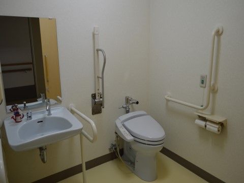 手すりと洗面台が備え付けられたトイレ。呼び出しボタンも設置されており、すぐに職員を呼び出すことができる。