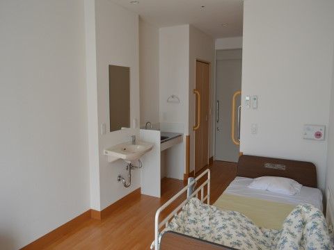 入口前の引き戸の手前にキッチンと洗面台が備え付けられた部屋