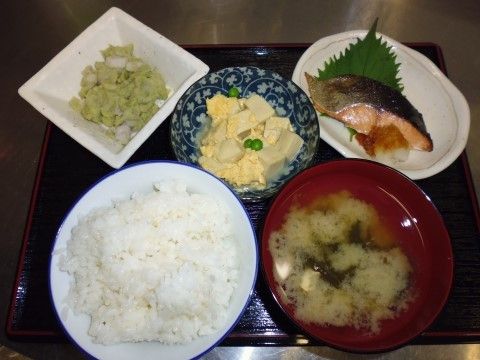 ごはんとみそ汁、焼き魚や高野豆腐が添えられている食事