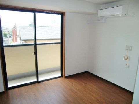 壁にナースコールとエアコンがあり、まだ家財道具がないきれいな部屋
