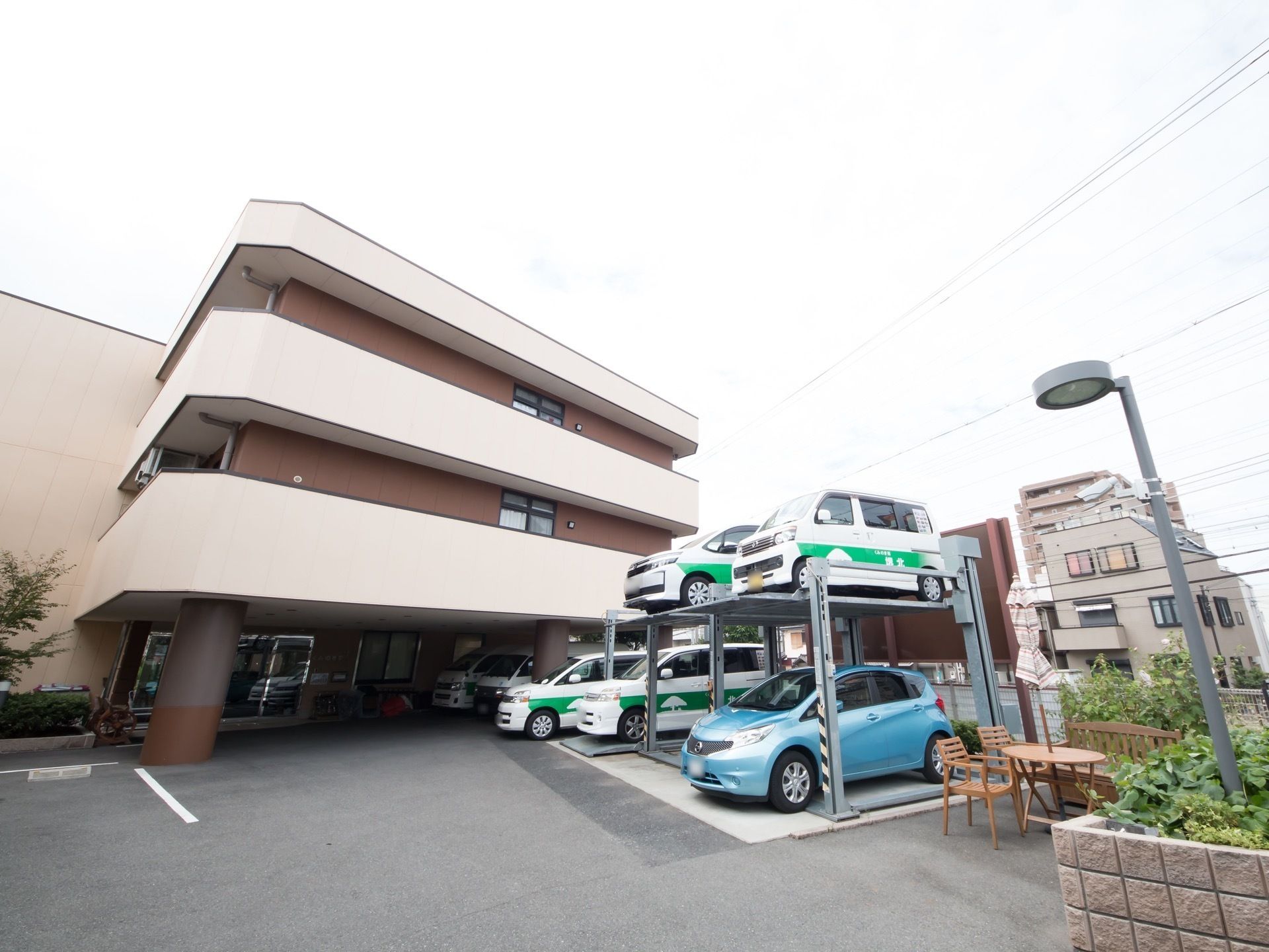 昇降式の機械駐車場があり、施設所有の車が停まっている施設前