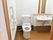 デイサービス内にある車イス対応型トイレです。介助なくご利用いただけるよう、フットレスの洗面台や手すりを設置しています。
