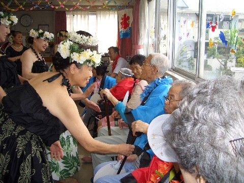 フラダンスショーを観覧した後、踊り手と握手や話をして交流を楽しむ入居者