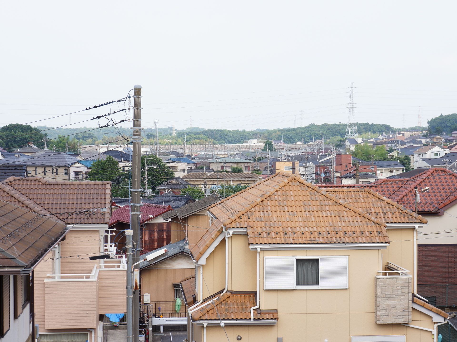施設の居室から眺めた近所の景色は、ベージュ色や茶色の屋根の家が集まっている住宅地を見渡すことができる。