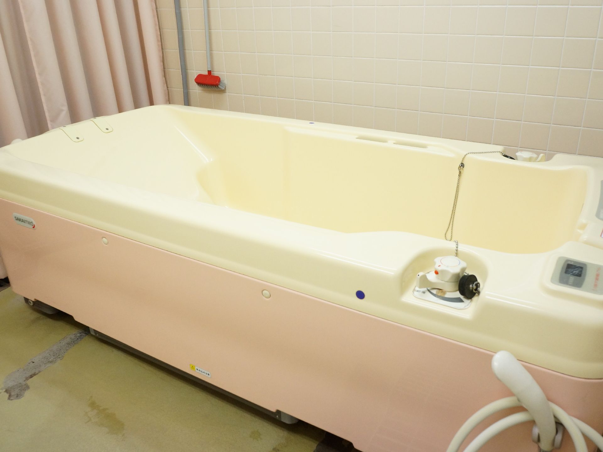 浴室に設置されたお風呂は、右側に温水や冷たい水、水温調整をすることができるボタンが取りつけられている。