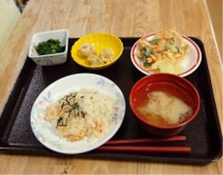 トレーに並べられた食事は、汁物とご飯に３皿のおかずである。日々の食事は生活や健康の基本となる大事な物である。
