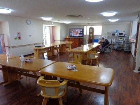 大きな木製のテーブルが細長く並べられているダイニング