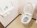 トイレには温水洗浄便座が設置されており、便座横に操作するためのパネルが取りつけられている。壁には非常ボタンがある。