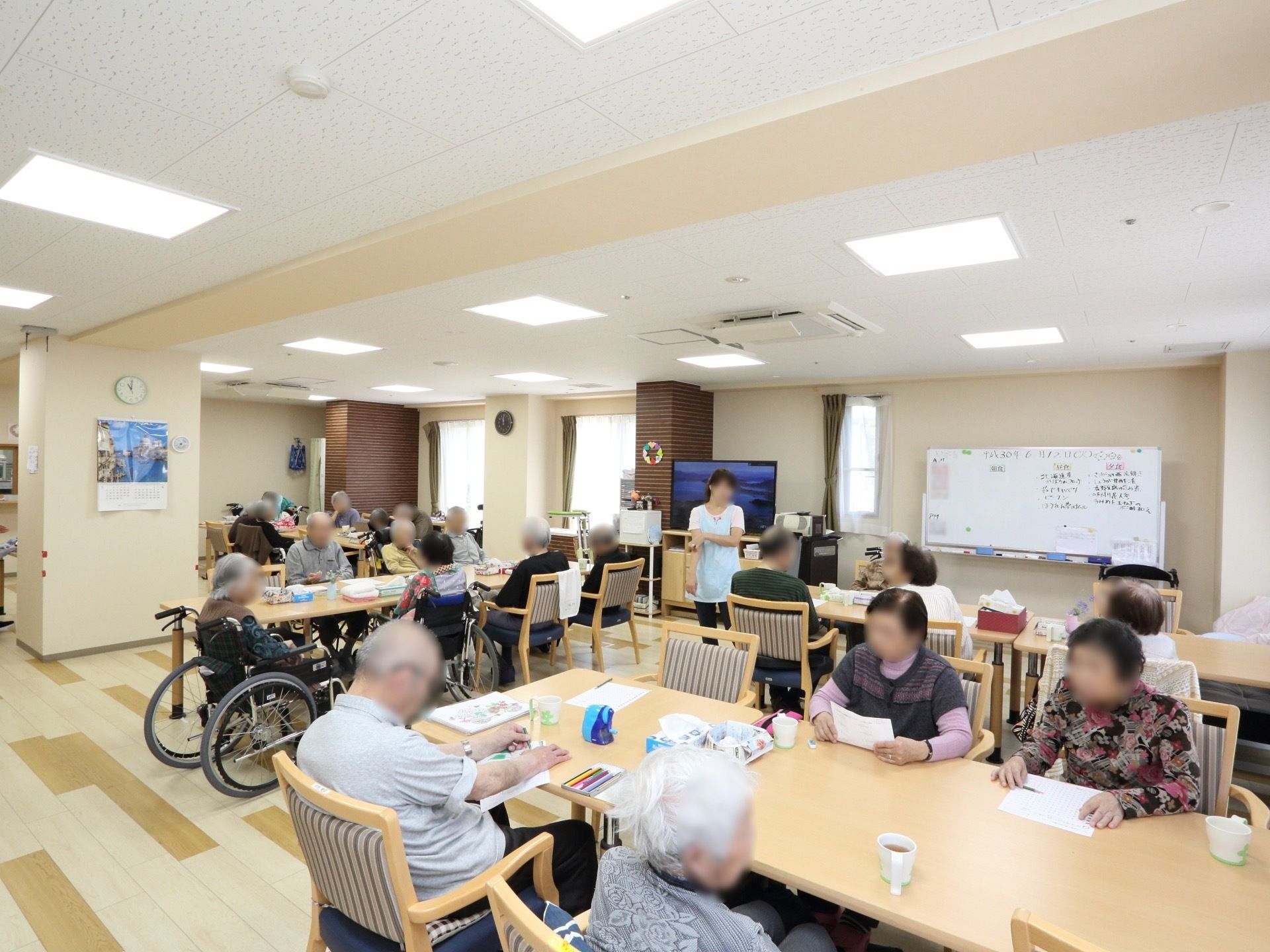 食堂に集まってレクリエーションを楽しむ高齢者の様子。