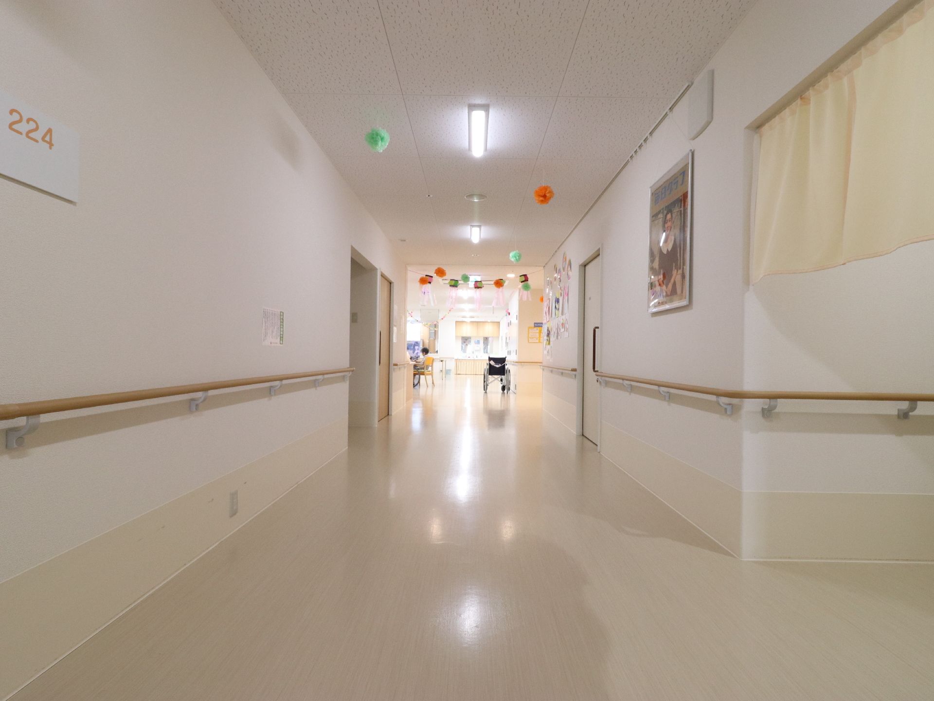 廊下の壁には絵画が飾られている。紙で作られた飾りも飾られている。フロアは段差が一切ない。扉は引き戸が多い。