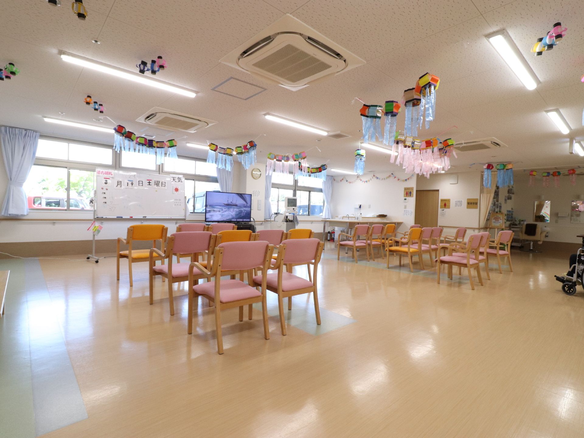 ホールに椅子が並べられている。入居者様が自発的に好きな事を実行してもらえるようにイベントやレクリエーションを行っている。