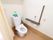 居室内のトイレ。洋式水洗トイレで、ペーパーホルダーの上に手すりが設置されている。ナースコールもあり、安全面に配慮されている。