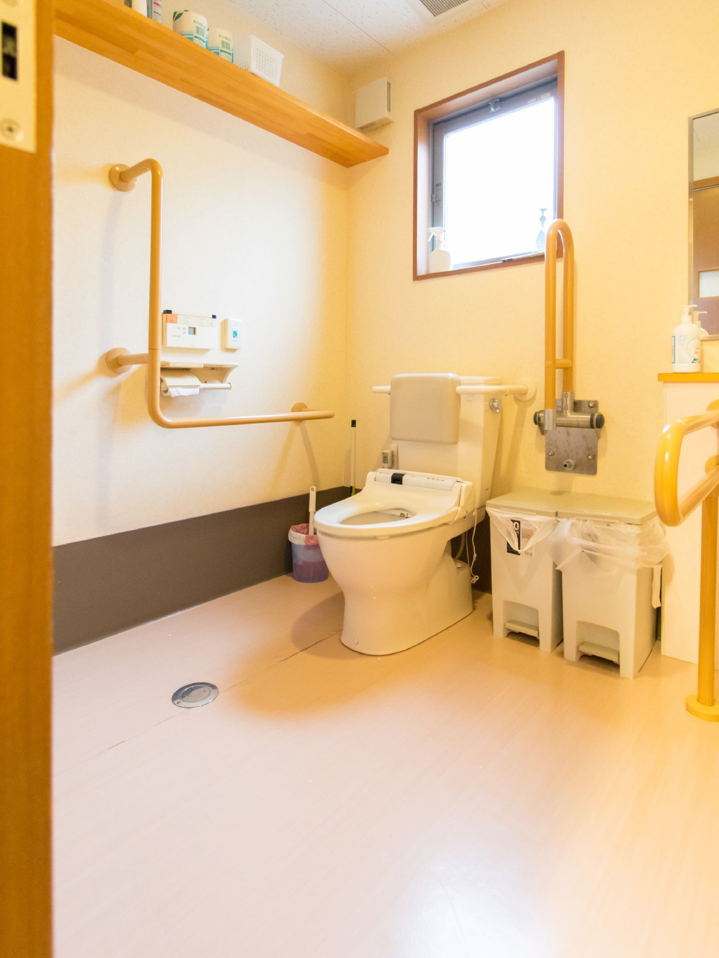 壁には手すりがついているほか、トイレのウォシュレット操作パネルが取り付けてある。もう片方の介護バーが跳ね上げ式で必要な時に使える。
