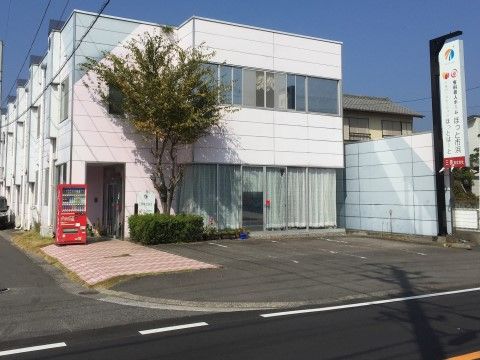 淡いピンク色と白を基調にした、明るい色合いの２階建て。玄関から道路までは滑りにくい素材で舗装されている。