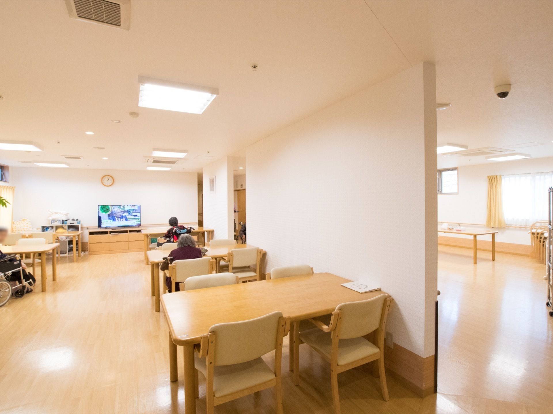 多くの座席が設けられている共有スペース。普段のリビングのほかに食堂も兼ねている。壁際には大型テレビが置いてある。