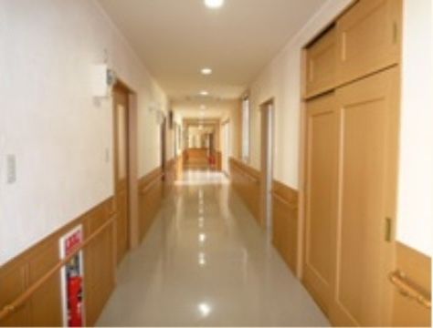 廊下の両側に居室の扉が並んでいる。扉以外の壁の部分には移動の補助にご利用いただける手すりを取り付けている。