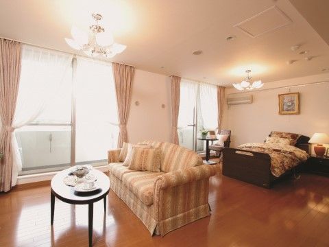 ３人で座ることができるソファや、アンティーク柄の布団が敷かれたベッドのある部屋