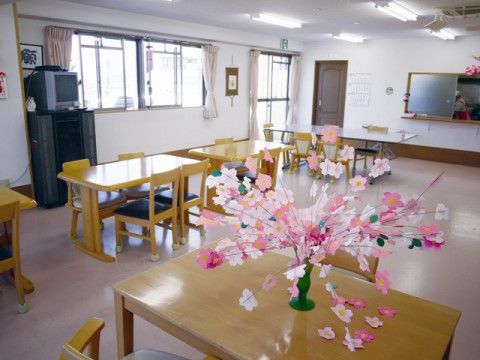 入居者様同士で食事を楽しめるよう、広く開放的なスペースになっている。窓が大きく明るい。テレビもあるので鑑賞できる。
