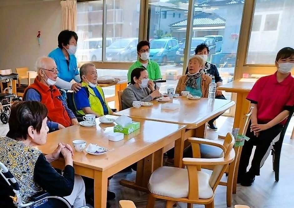 談話室から見える景観である。雲ひとつない晴天。左側には住宅地が広がり、右側には田畑が広がっている。遠くに日本一の山が見える。