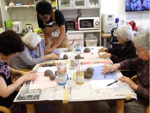 スタッフのサポートを受けながら、油粘土をこねている入居者様