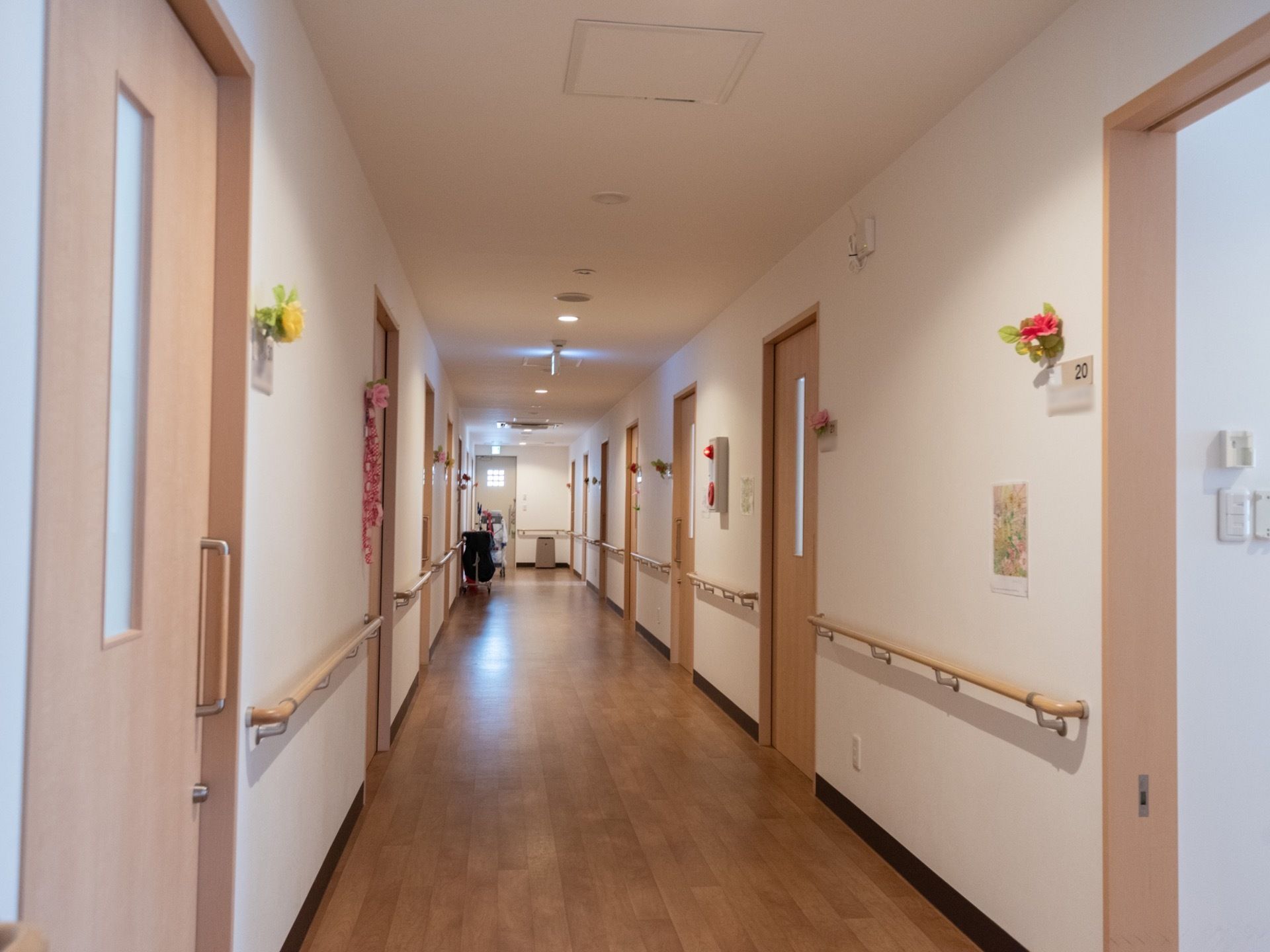 廊下の突き当たりに小窓のついたドアがある。左右両側に部屋があり、さまざまな色の花がプレートに飾られている。