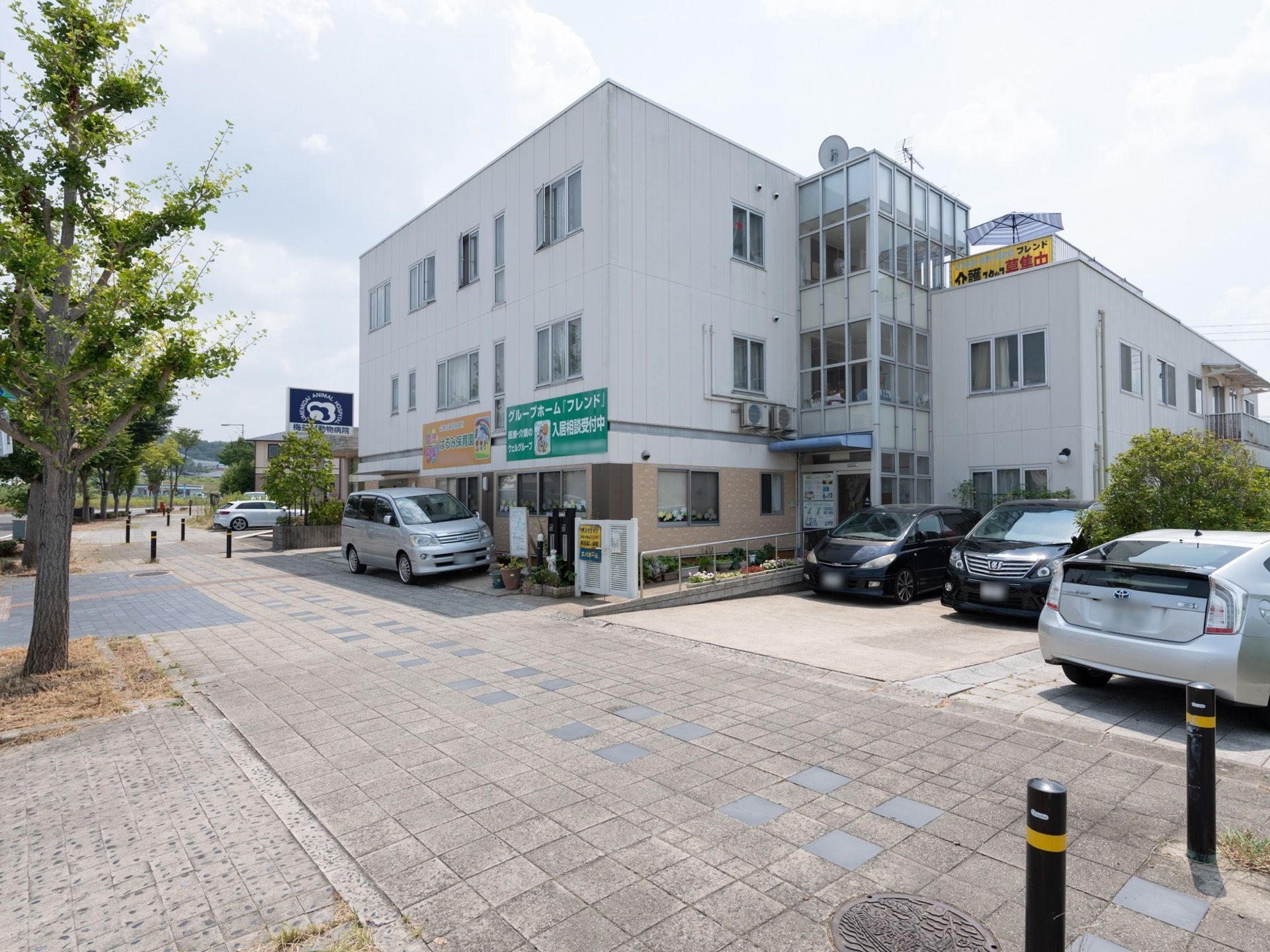 施設は縦に伸びる形の3階建ての建物であり、各所に窓が配置されている。歩道と施設の入口へと続くスロープとの間には白色の小門が設置されている。