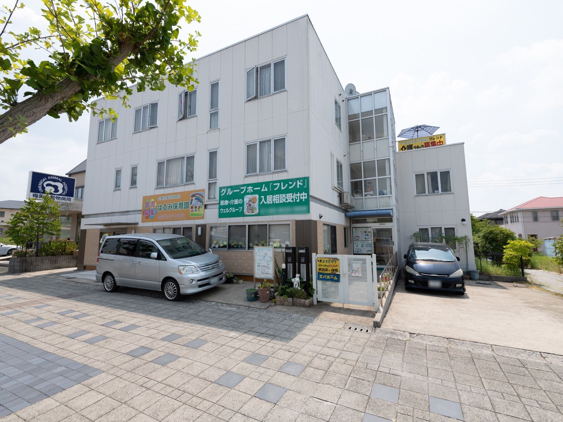 白を基調とした３階建ての施設である。周辺に高い建物がなく、日当たり良好の環境である。駐車スペースも確保されている。