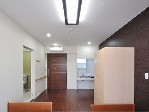 焦げ茶色のフローリングの上に、白いタンスが設置されている部屋