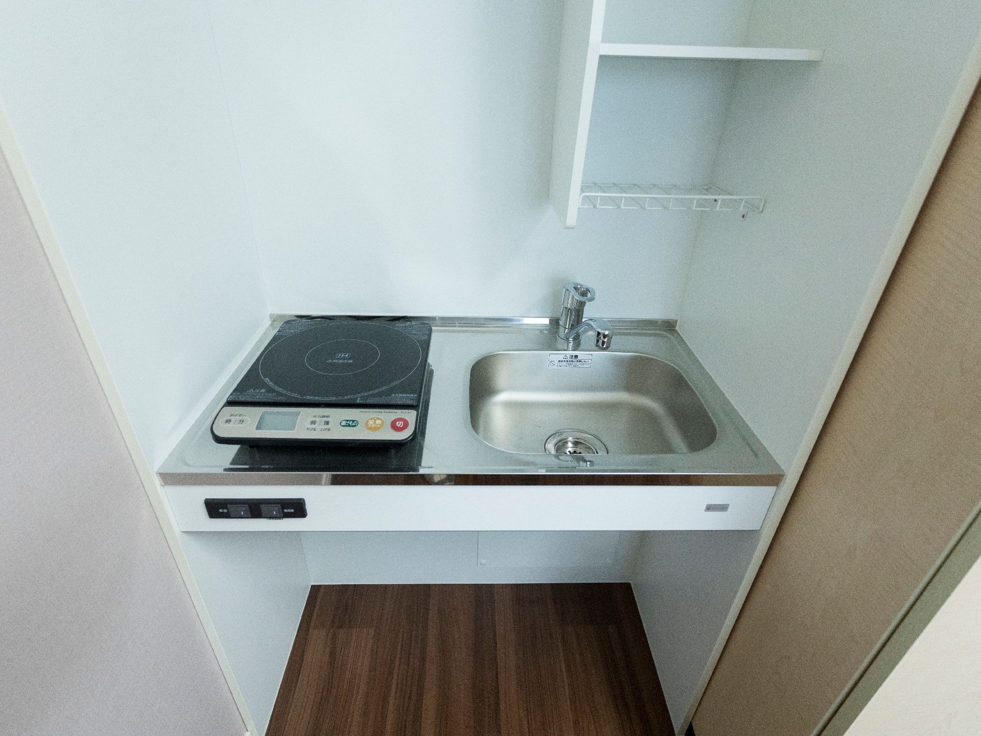 左側にはIHヒーターが置かれている。右側にはシンクがある。シンクの水道はレバー式の蛇口になっている。