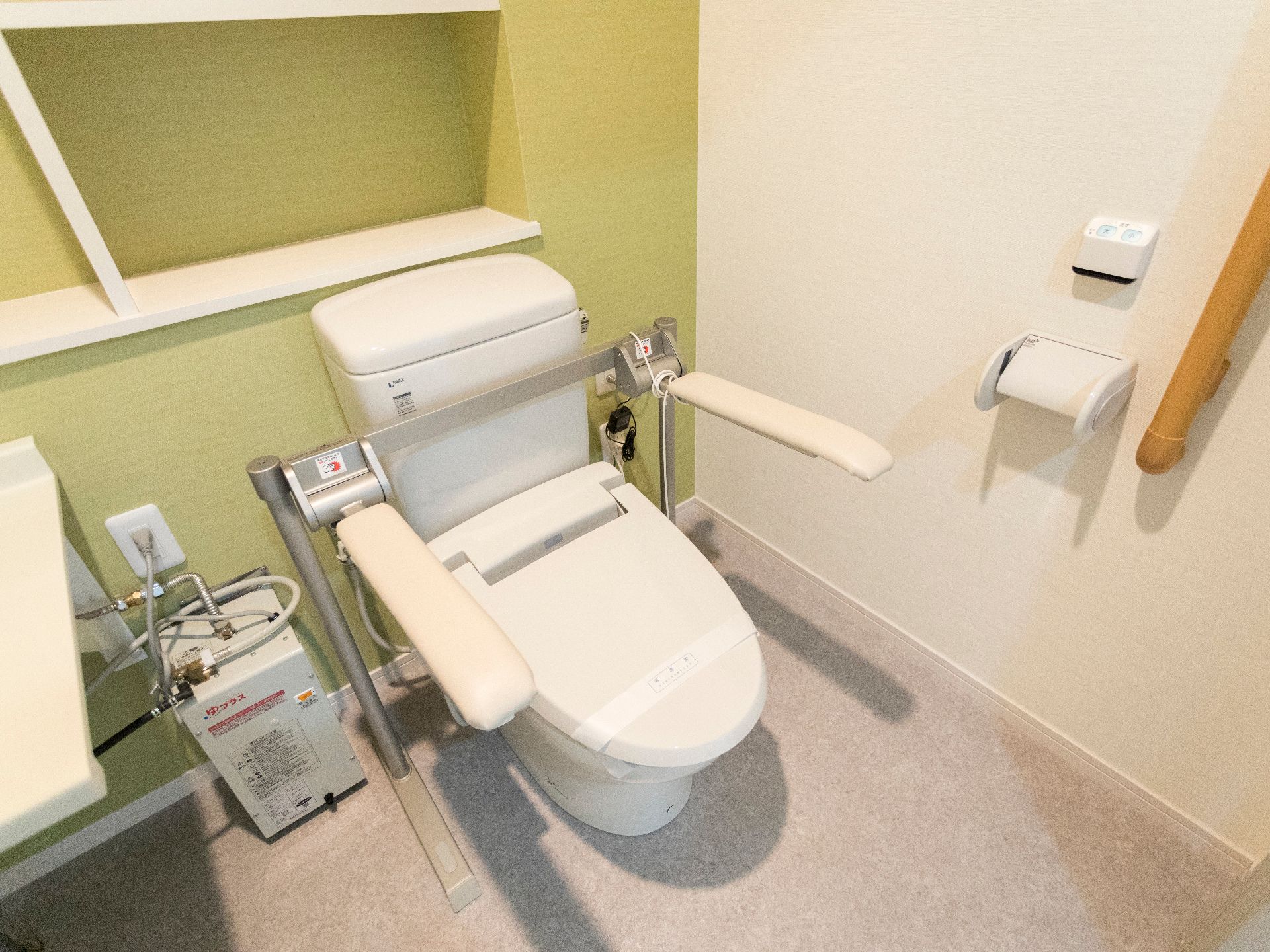 居室のトイレは、両側に安定したひじ掛けが付いている他、立ち上がる際の補助となる手すりも設置されており、安全に配慮されている。