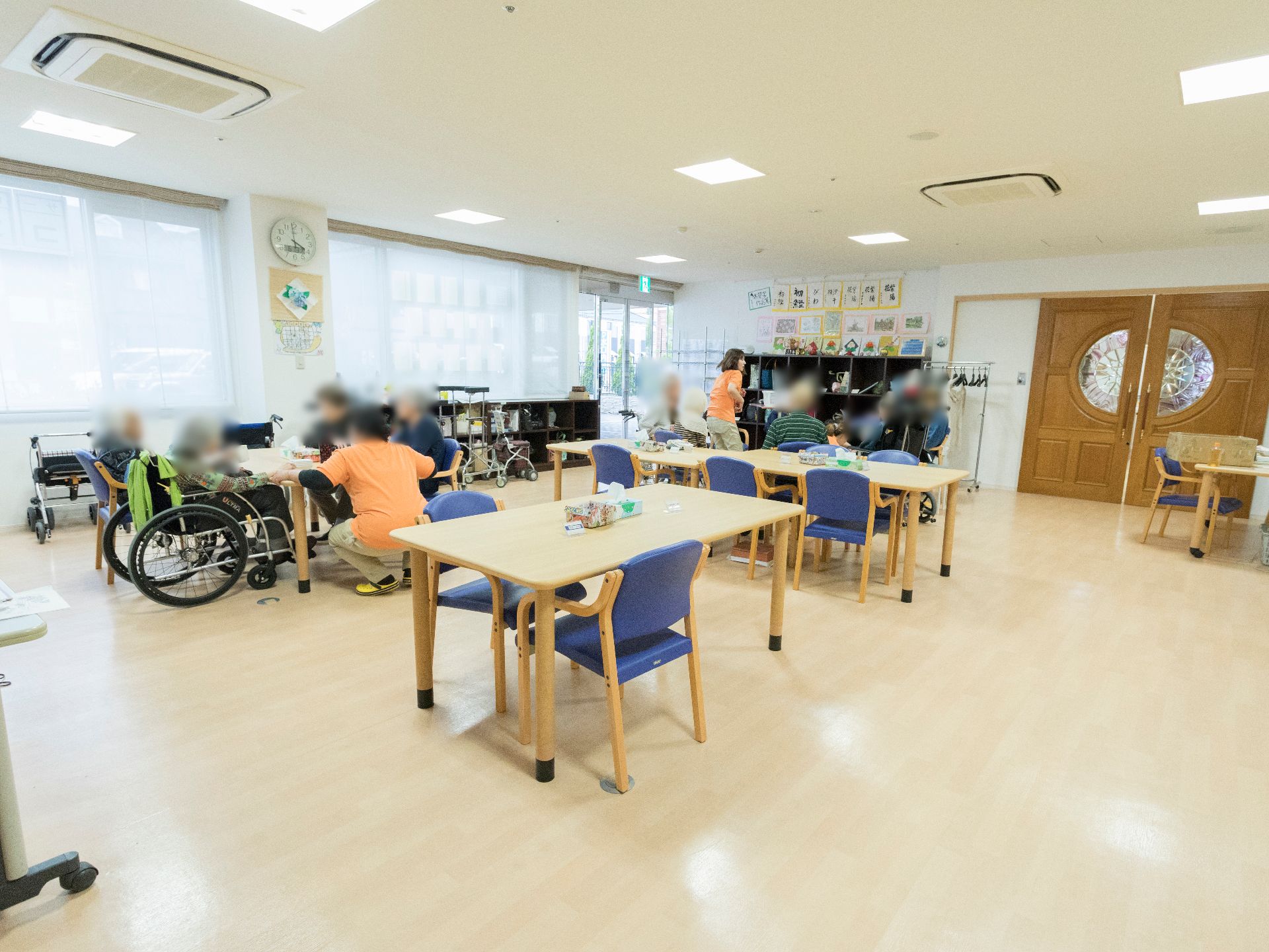 施設1階にあるデイサービスは、多くの椅子や机が並び、多くの利用者を迎えることができる。また、空気清浄機が設置され、衛生面にも配慮されている。