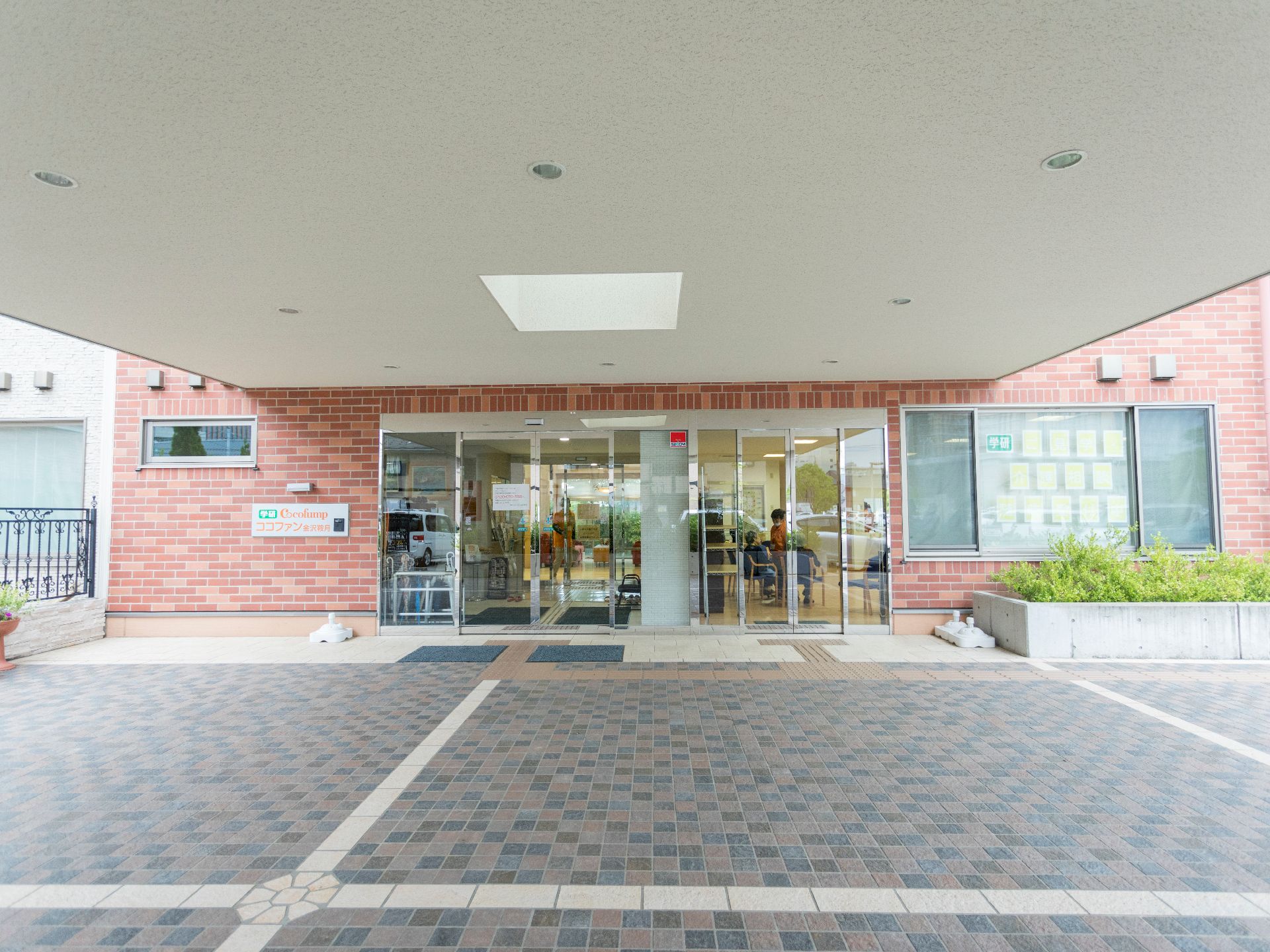 施設の屋外から玄関前に続く通路には点字ブロックが設置されている。また、広いスペースが設けられており、段差がないエントランスとなっている。