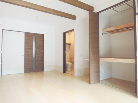 部屋の中に、棚やポールが設置された広いクローゼットが設置されている居室