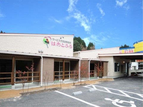 ご家族やご友人などが気軽においでいただけるよう、建物の前面に広い駐車場を用意している。入り口前には手すりも完備。