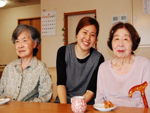 おやつの時間を楽しむ高齢者と女性スタッフ