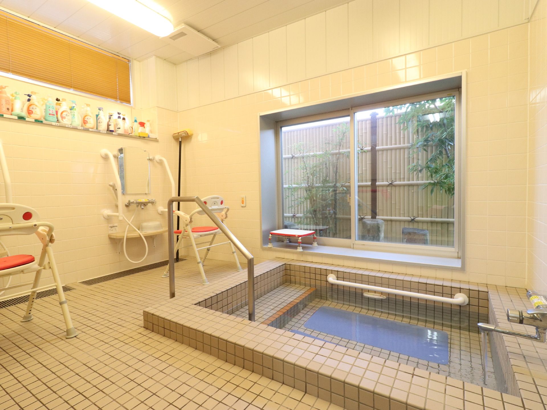 湯船が正面にある。そこの左側は階段になっており、階段に沿って手すりが付いている。湯船や床や壁はタイル張りになっている。